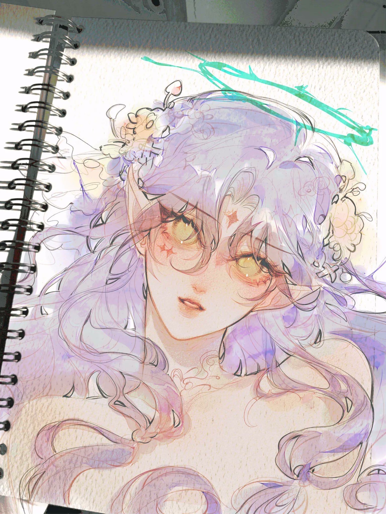 the image shows a closeup of a sketchbook page featuring a digital or watercolor painting of an animestyle girl.  she has long, flowing purple hair adorned with a delicate flower crown.  she possesses elflike ears and a halolike feature is sketched above her head.  her expression is soft and gentle, and her features are delicately drawn with pastel and watercolorlike shading.  the overall style is ethereal and dreamy, suggesting a fantasy or magical theme. the artwork is bathed in soft light, giving it a luminous quality.  the page appears to be in a spiralbound sketchbook.
