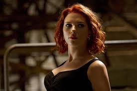 a closeup portrait of scarlett johansson portraying black widow from the marvel cinematic universe. she has vibrant red, curly hair and is wearing a simple black dress.  the background is dark and blurred, emphasizing her intense expression and features. the lighting is focused on her face, creating a dramatic effect.  she appears serious and focused.