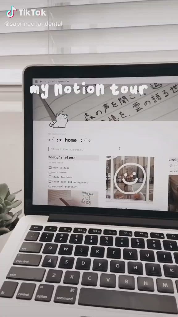 a closeup shot of a laptop with the screen displaying a notion page titled "my notion tour". the page is in a clean, minimal aesthetic with a list of todos for the day. the keyboard is black with white letters, and the laptop is on a white surface.