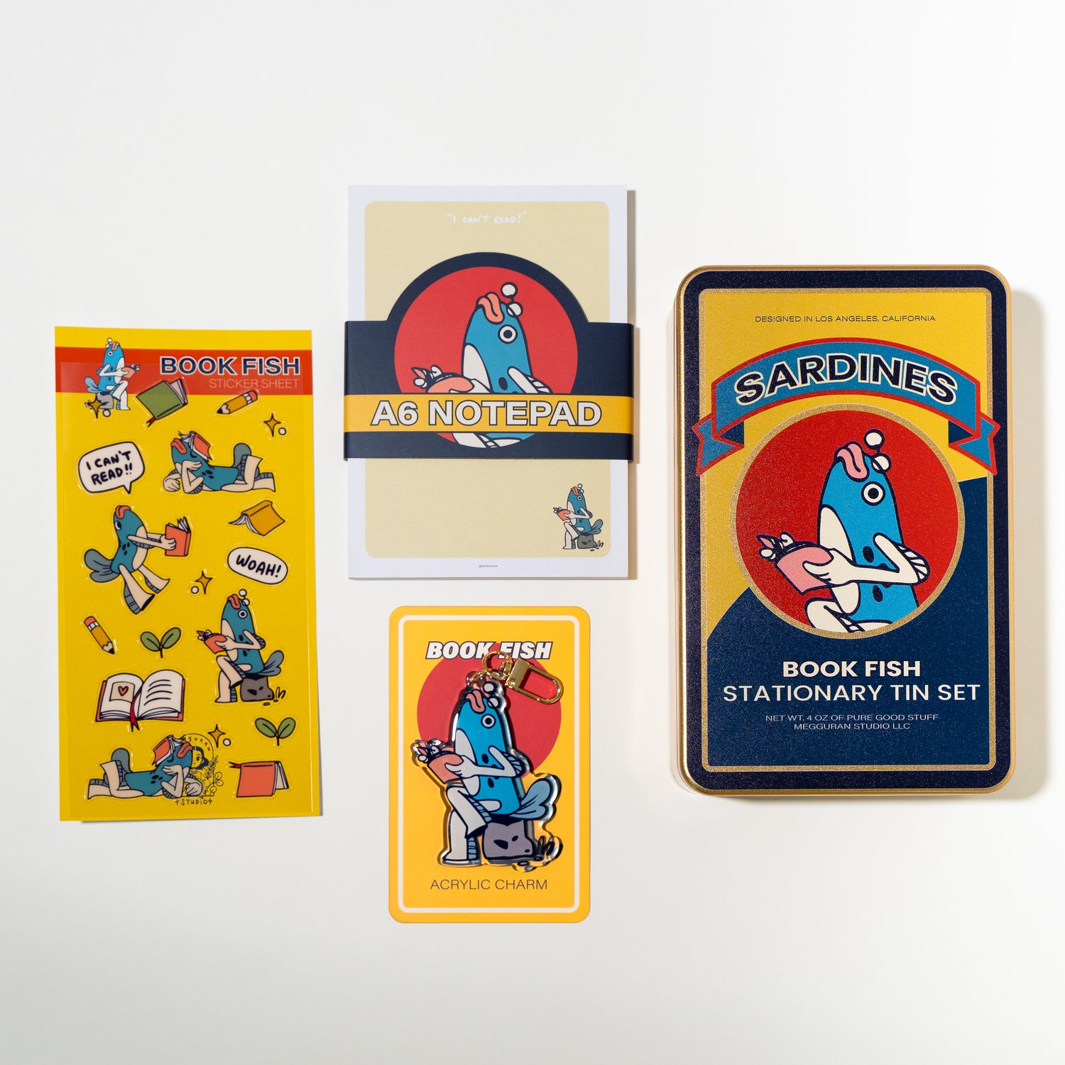 flatlay image showcasing a book fish themed stationery set. the set includes an a6 notepad, a sticker sheet featuring various book fish illustrations, an acrylic charm, and a tin set with the label “sardines.” all items share a consistent retroinspired design with a yellow, blue, and red color palette. the items are arranged on a white background, highlighting each piece individually. the overall aesthetic is cute and playful, ideal for stationery lovers or as a gift set.