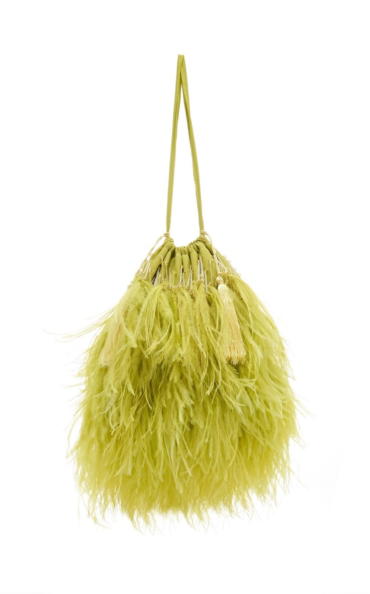 a green ostrich feather purse hangs against a white background. the purse has a soft, feathery texture and a drawstring closure with tassels.