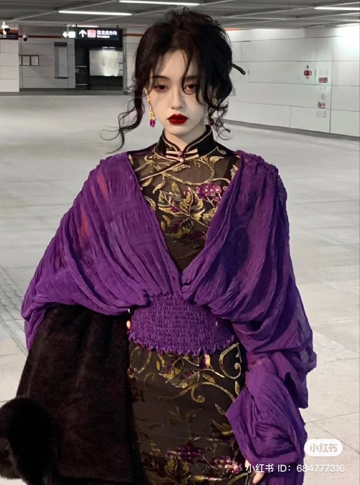 a young asian woman in a purple dress, standing indoor. she is looking directly at the camera with a confident look, she has long black hair, styled with big curls. she is wearing red lipstick and a pair of earrings,  and looking stunning.