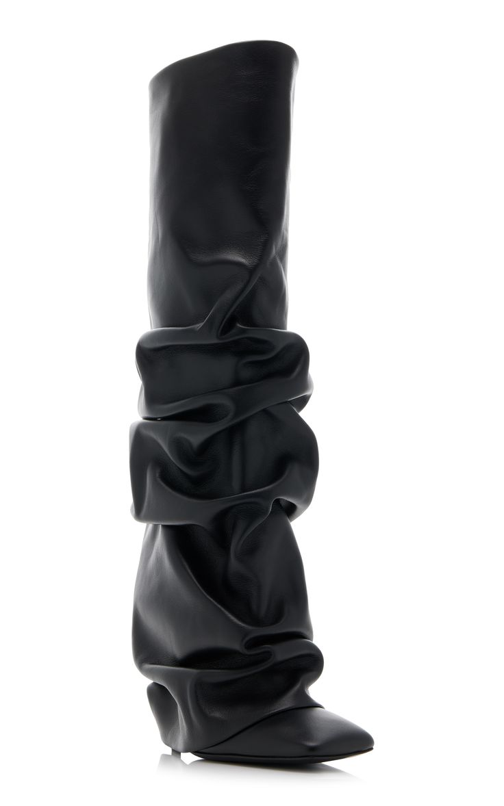 the image showcases a single, black leather kneehigh boot.  the boot is distinguished by its unique, gathered or slouched design, creating a textured and draped effect on the shaft.  the boot appears to have a subtle wedge heel and is presented on a white background in a side profile view.  the leather looks smooth and supple.  the overall style is contemporary and fashionforward.