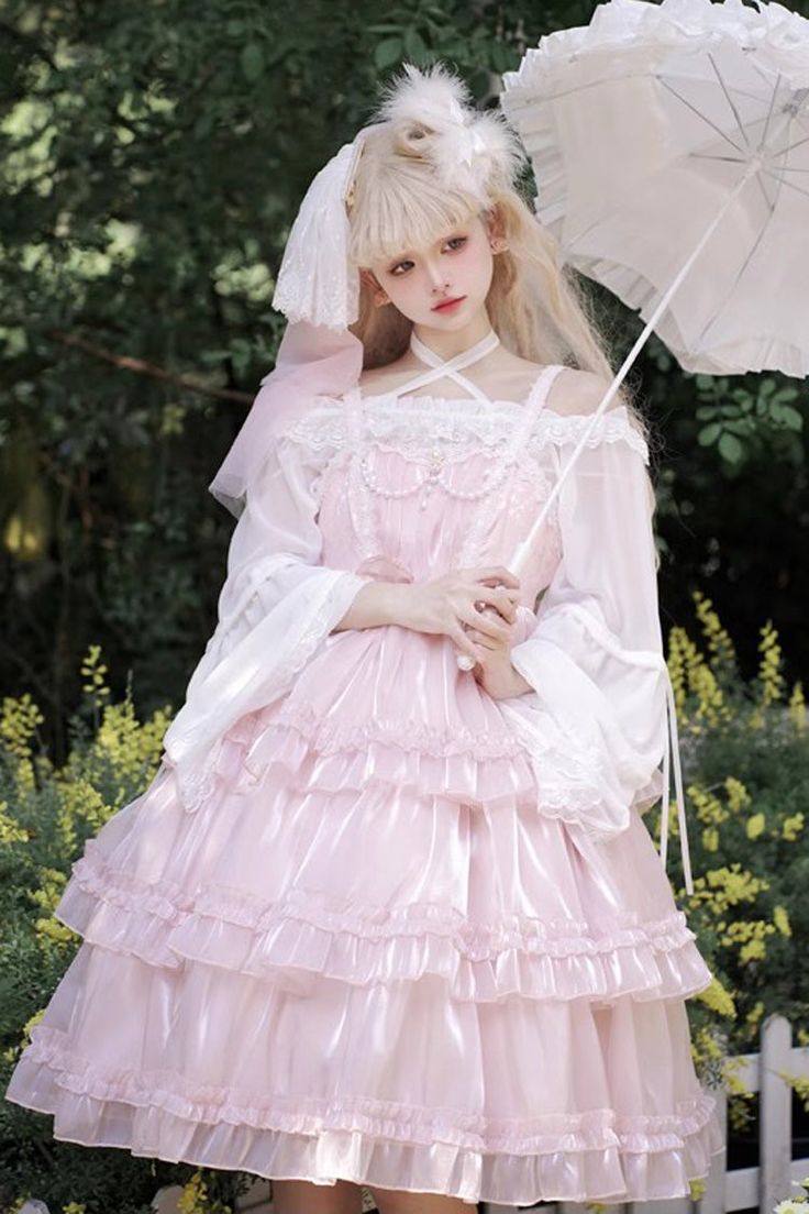 a young woman in a pink lolita fashion dress poses in a garden. she is holding a white parasol and has a bow in her hair. the dress is long and flowing, with multiple layers of frills and lace. the garden is lush and green, with yellow flowers in the background. the lighting is natural and daylight, giving the image a soft and dreamy feel.