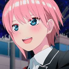 the image is a closeup of ichika nakano, an anime character from the series quintessential quintuplets. she has short, pink hair and bright blue eyes. she's wearing a school uniform and has a warm, inviting smile. her cheeks are slightly flushed, indicating a hint of embarrassment or happiness. the background is blurred, but appears to be an outdoor setting.