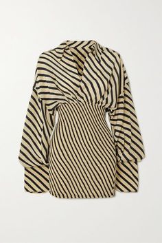 a women's striped mini dress with long sleeves. the dress is black and white striped and has a fitted bodice with a flowy skirt. the dress is styled with a relaxed fit and is perfect for a casual party or event.