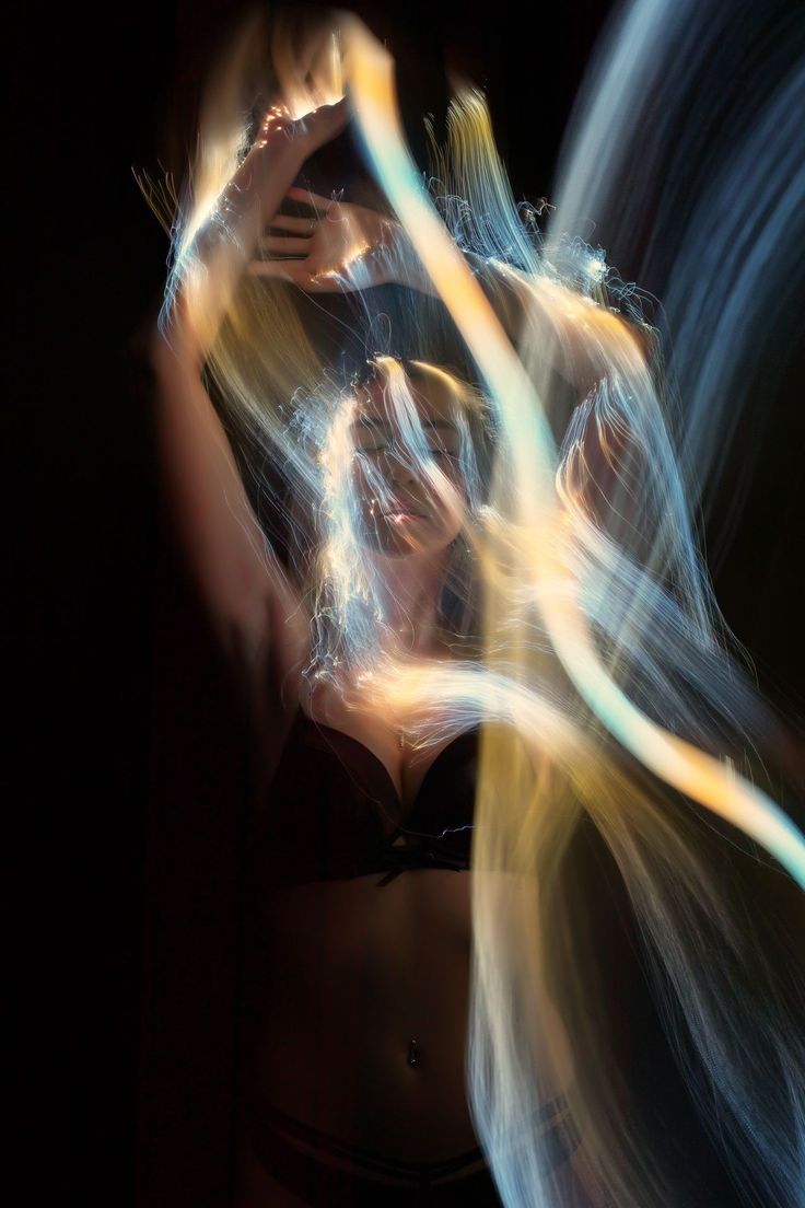 a woman is posing in a dark studio.