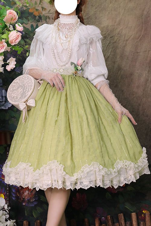 a woman is wearing a green lolita fashion outfit. the outfit consists of a light green skirt with lace trim, a white blouse with lace details, and a pearl necklace. she is also carrying a round white bag with a floral pattern. the background features a wall with floral patterns. the lighting is soft and diffused, creating a dreamy and romantic atmosphere.