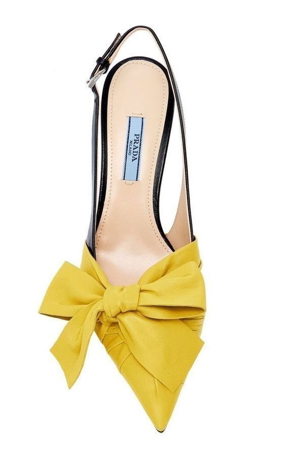 a closeup of a yellow prada slingback heel with a bow.