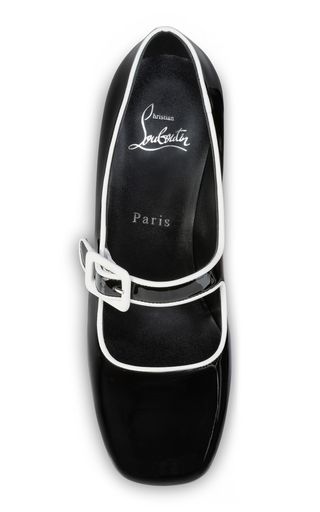 a pair of black patent leather women's pumps with a white trim and a buckle. the shoes are by the designer christian louboutin and have a red sole.