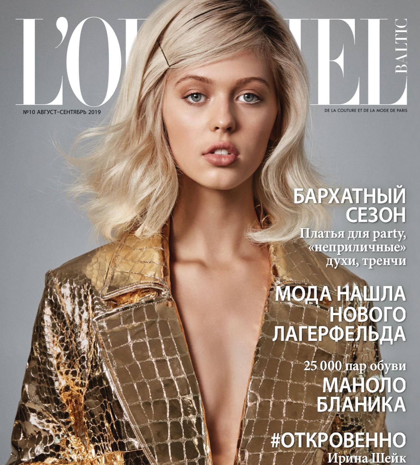 a magazine cover featuring a young, blonde model wearing a gold crocodilepatterned jacket. the magazine is l'officiel, the augustseptember 2019 issue, with russian text including the name irina shayk.