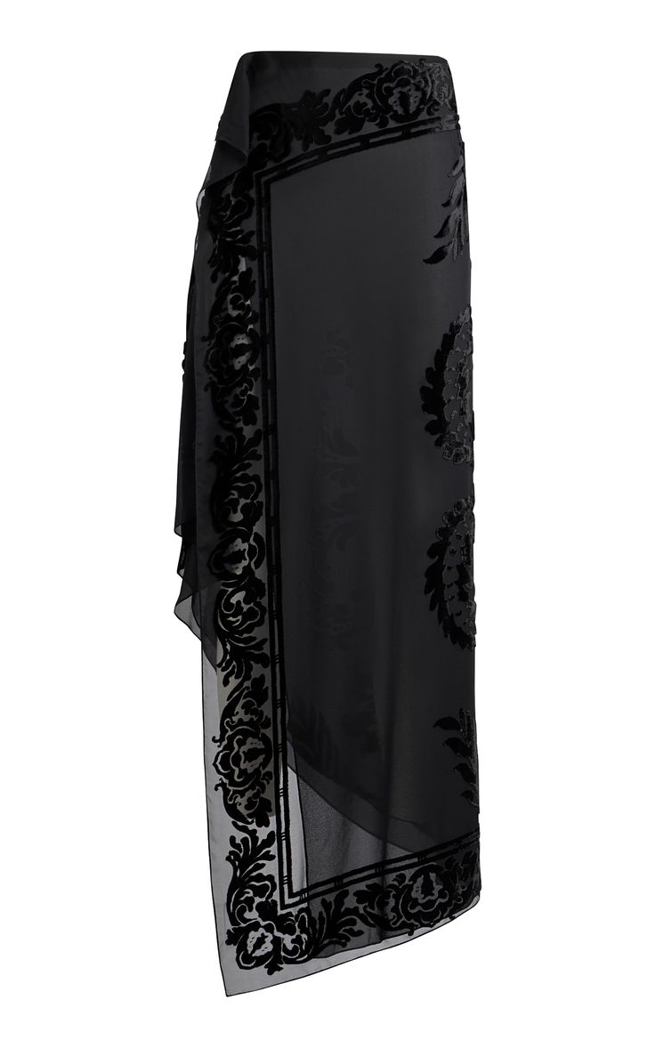 a black skirt with a black velvet floral pattern on the hem. it's a long, flowing skirt that appears to be made of a lightweight fabric.  the skirt is fitted through the waist and hips and flows out to a wide hem. the skirt appears to be a highquality piece of clothing.  it would be perfect for a special occasion.