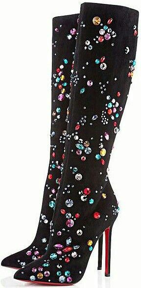 a pair of black suede kneehigh stiletto boots covered in multicolored rhinestones. the boots are set against a white background.
