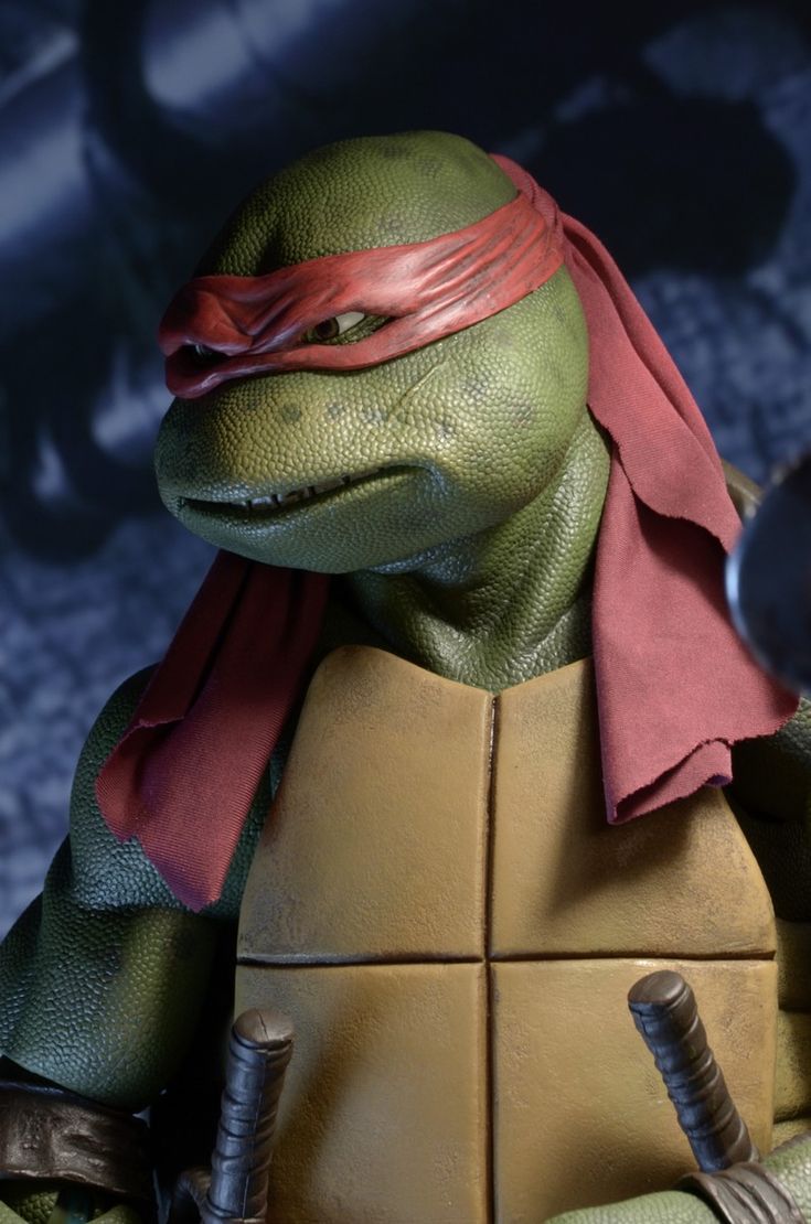 a close up of the teenage mutant ninja turtles character leonardo, wearing his signature red bandana and holding his two katana swords.