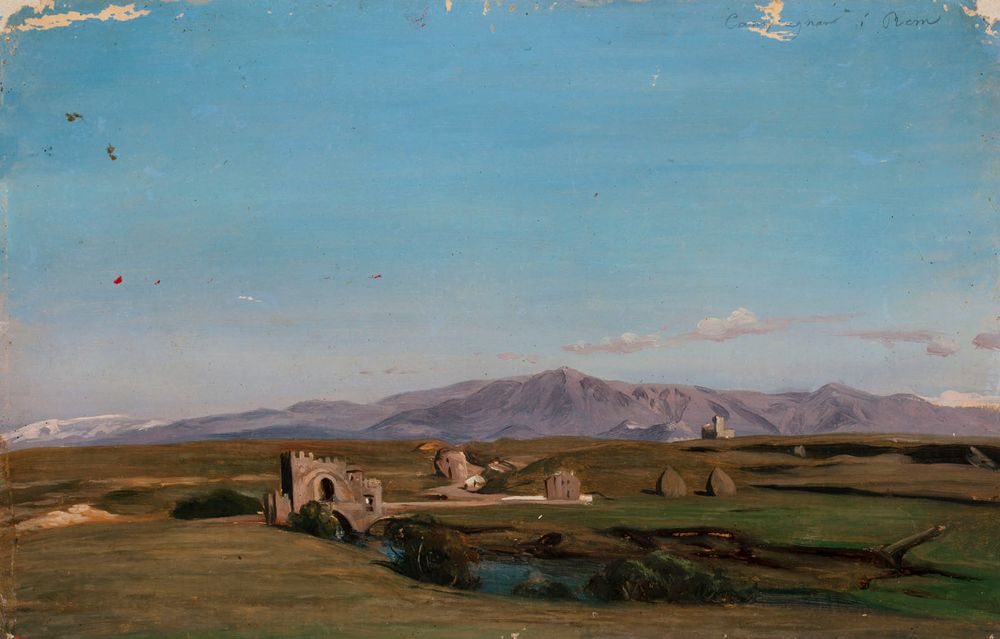 a landscape painting titled "campagna di roma" depicts a vast field with ruins and mountains in the background. in the foreground, there is a river with trees on its banks. in the field, there are several ruins, including a towerlike structure and an archway. there are also haystacks scattered throughout the field. in the background, there are mountains under a blue sky with some clouds.