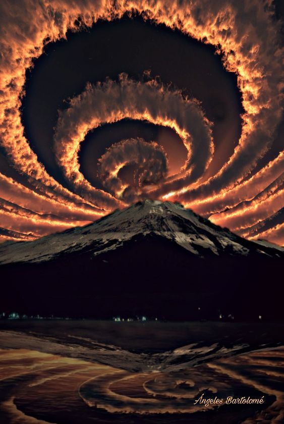 an artistic photo with a mountain silhouette in the foreground and a fiery swirling spiral of clouds in the sky. the clouds are fiery orange and red and swirl in a vortex that draws the eye to the center of the photo. the mountain is silhouetted against the sky and is framed by the swirling clouds. the image has a dramatic and artistic feel.