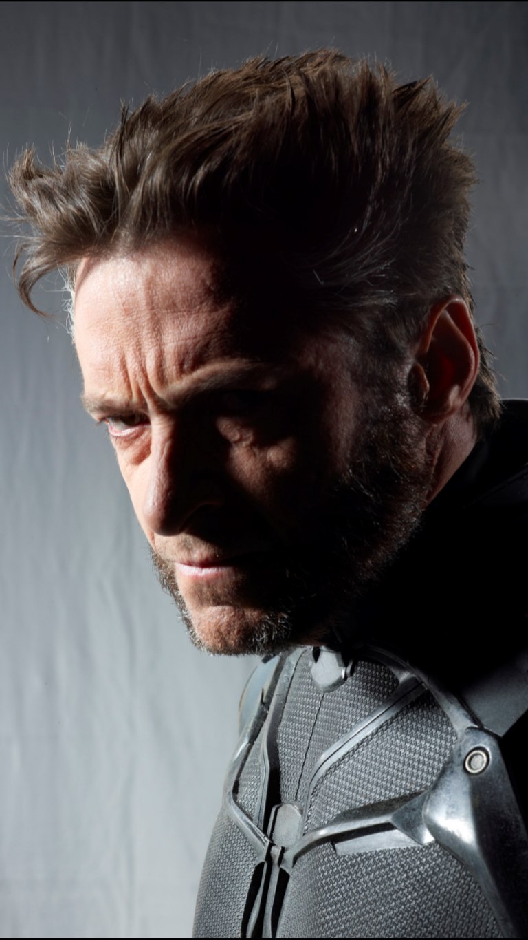 a portrait of hugh jackman as wolverine, in character and wearing a costume, with a serious and scowling expression.