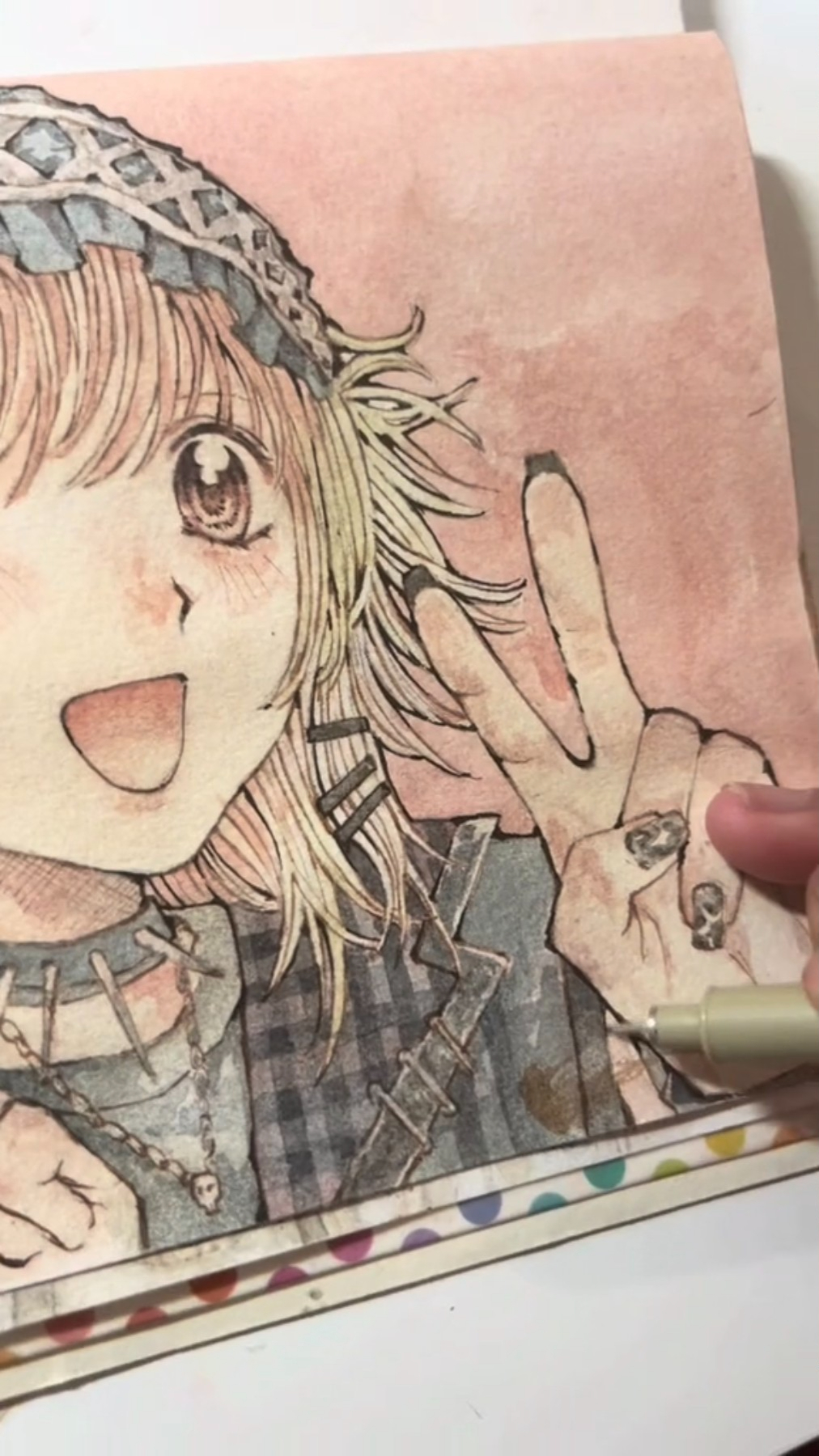 a closeup shot of an artist's hand drawing an anime girl making a peace sign. the drawing is done on paper with a pen and pencil, and the artist is sitting at a table. the drawing is colorful and detailed. the artist is in the process of completing the drawing.