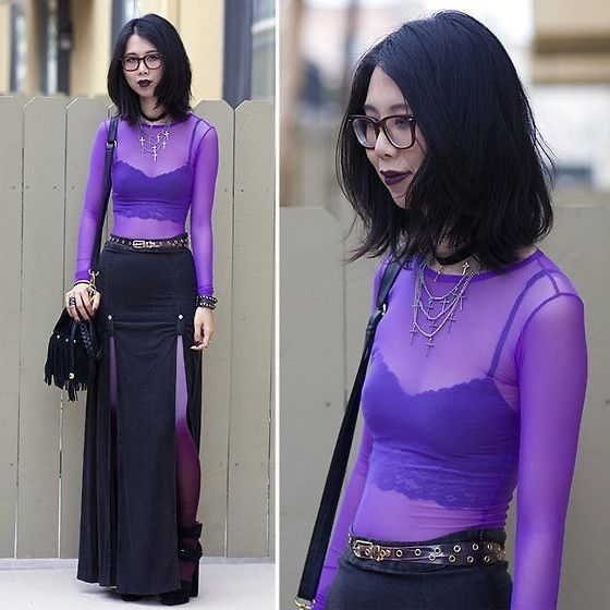 the image is a collage showing two photos of a young asian woman wearing a purple outfit. she is wearing a sheer, longsleeved, purple mesh top over a purple bra, a black maxi skirt with a slit, black heeled ankle boots, and several necklaces including a choker and a cross necklace.  she's also carrying a fringed black handbag and wearing glasses.  the setting appears to be outdoors, with a wooden fence visible in the background. the overall style is goth or grungeinspired.  the two photos show slightly different angles of the same outfit.