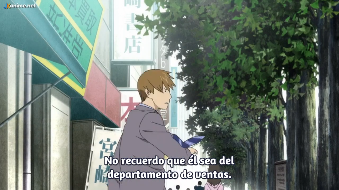 the image is a screenshot from an anime. it shows a man in a suit and tie walking down a city sidewalk. he is looking back over his shoulder at a woman walking behind him. there are trees and buildings lining the street.```