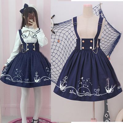 two images of a navy blue and white sailor dress with whale embroidery. one image shows the dress on a woman, and the other shows the dress on a mannequin.