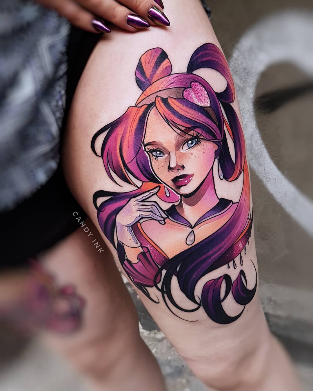 the image shows a colorful animestyle portrait tattoo of a woman on someone's right thigh. the woman in the tattoo has pink and purple hair styled in a high ponytail, blue eyes, and is wearing pink lipstick and a pearl necklace. she is holding a pink heartshaped object in front of her mouth. the tattoo is highly detailed and realistic, with smooth shading and blending of colors. the background of the tattoo is black, which makes the colors of the portrait pop even more.
