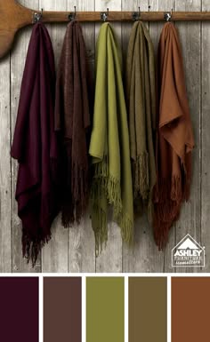 a close up photo of five different throw blankets, hanging in a row on a rustic wooden board. the throw blankets are in various colors, including brown, green, maroon, and a burnt orange. a color palette of the blankets is shown below the image.