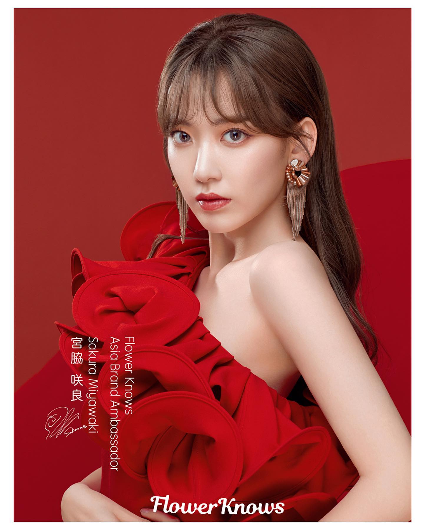 he image showcases sakura miyawaki, a japanese idol, as the brand ambassador for flower knows. she's elegantly dressed in a vibrant red, offshoulder dress, posing against a matching red background. her makeup is flawless, highlighting her features, and her hair is styled with a fringe, cascading down her back. the studio lighting emphasizes her beauty, creating a captivating portrait. the brand name, "flower knows," is prominently displayed in the bottom right corner, further cementing the association.
