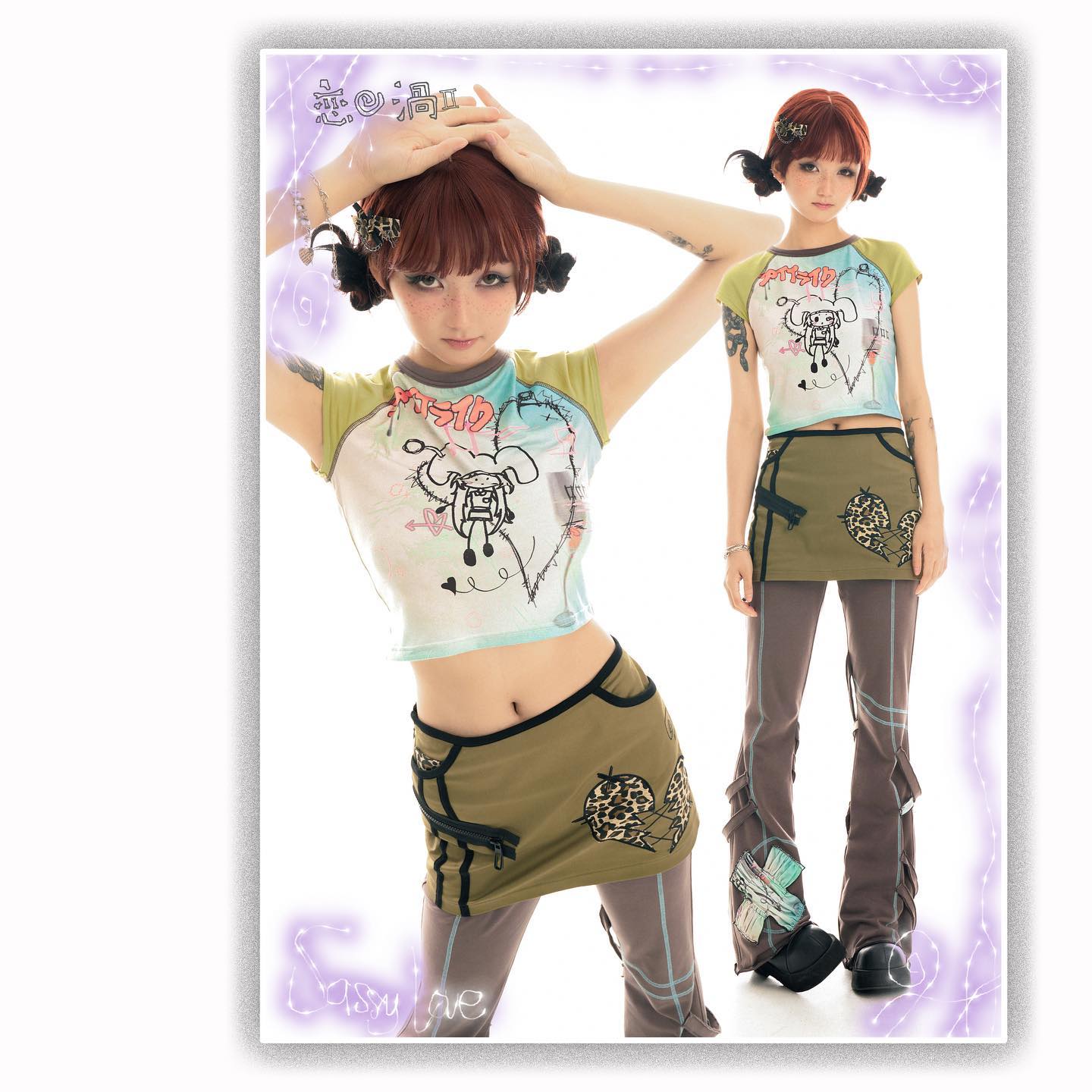 the image showcases two models, dressed in similar outfits from the brand "sassy jae".  both models are wearing a pastelcolored crop top featuring cartoonish graphics, paired with a khaki mini skirt adorned with leopard print and a zipper detail, and gray pants underneath. the first model is shown from the waist up, highlighting the clothing details, while the second model is shown fulllength, displaying the complete outfit and pose.  both models have reddishbrown hair styled in a way that's similar. the backdrop is a simple white studio setting, with a purple border and text overlays suggesting a playful, youthful, and trendy aesthetic. the overall style is reminiscent of harajuku fashion, characterized by its playful, cute, and often rebellious designs.