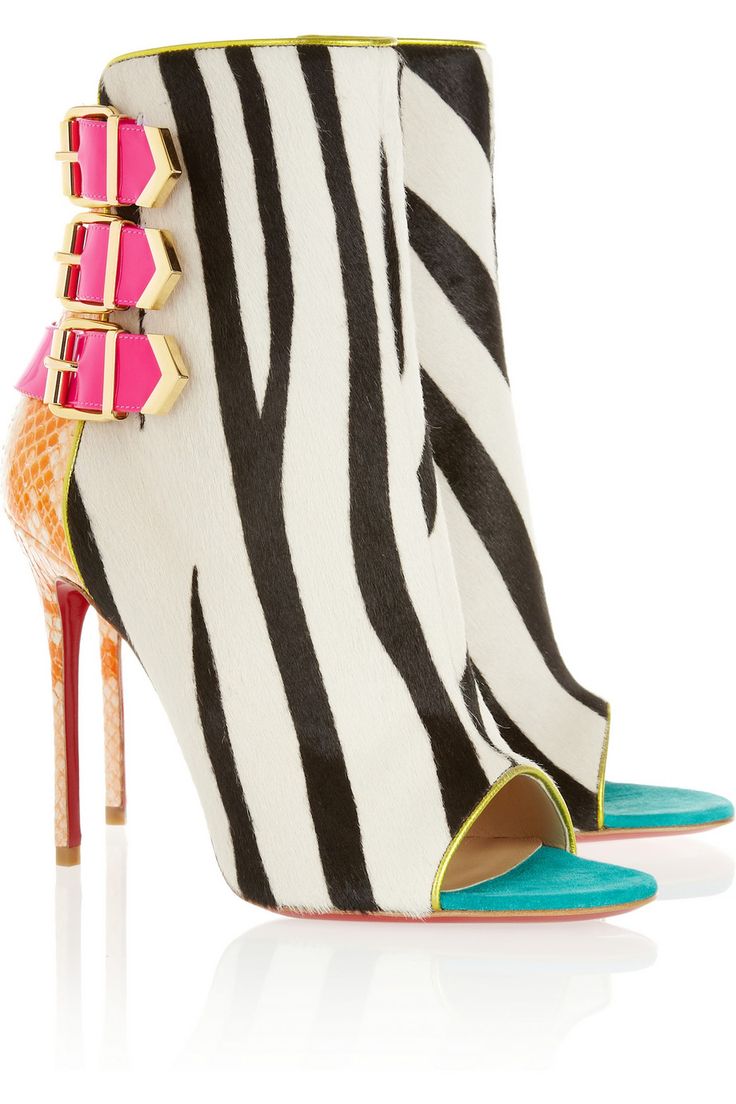 a close up of a zebra print stiletto heel with an open toe, featuring bright pink and green accents. the shoe has an ankle strap with buckles.
