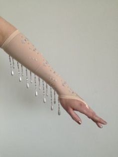 a woman's arm and hand wearing a beige beaded lace glove. the glove has a delicate, netlike design with a beaded trim, creating a stylish and elegant look. the background is plain white, allowing the focus to be on the glove itself. the image highlights the intricate details and craftsmanship of the accessory.