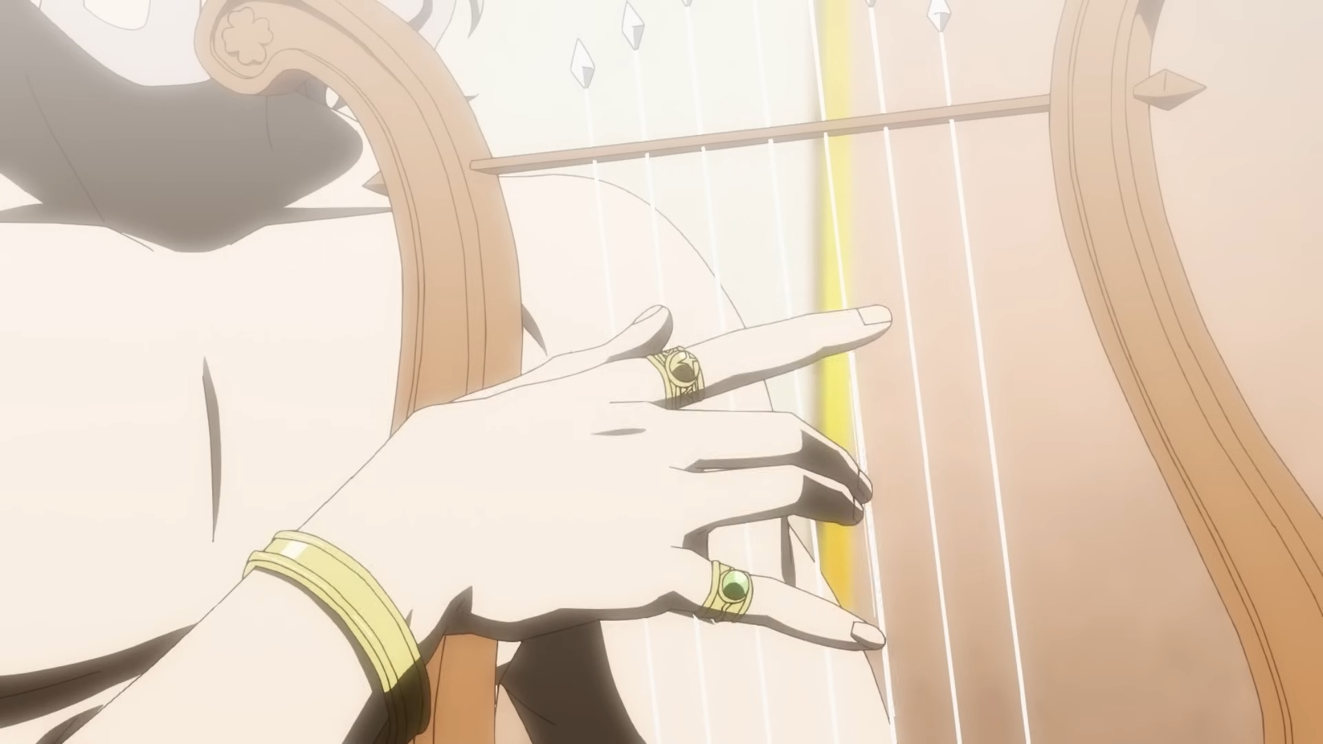 a closeup shot of a person's hands playing a harp. the hands are adorned with gold jewelry, including two rings and a bracelet. the harp is made of wood and has gold strings. the background is brightly lit.