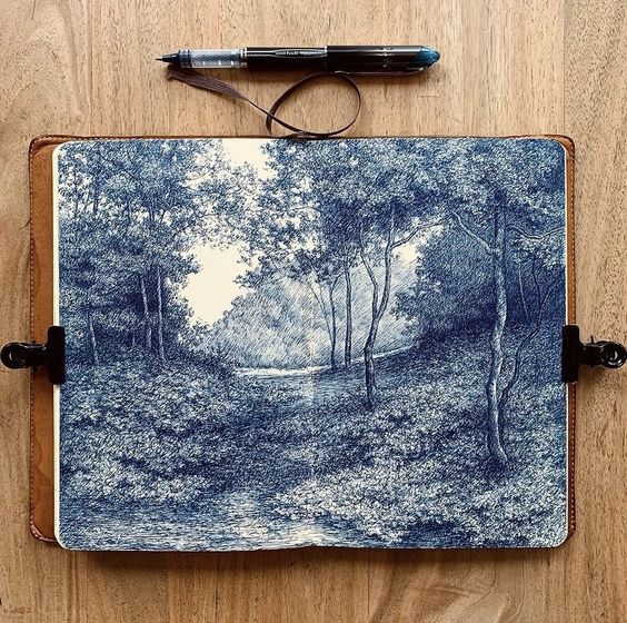 highangle, closeup shot depicts a leatherbound sketchbook laying open on a wooden surface.  the sketchbook contains a detailed pen and ink drawing of a tranquil forest scene, rendered in shades of blue ink. the drawing depicts a path winding through a sundappled woodland, with trees lining the path and a stream visible in the distance. a pen is placed above the open sketchbook, suggesting the artist's tools. the overall mood is serene and peaceful, reflecting the calming nature of the scene depicted.