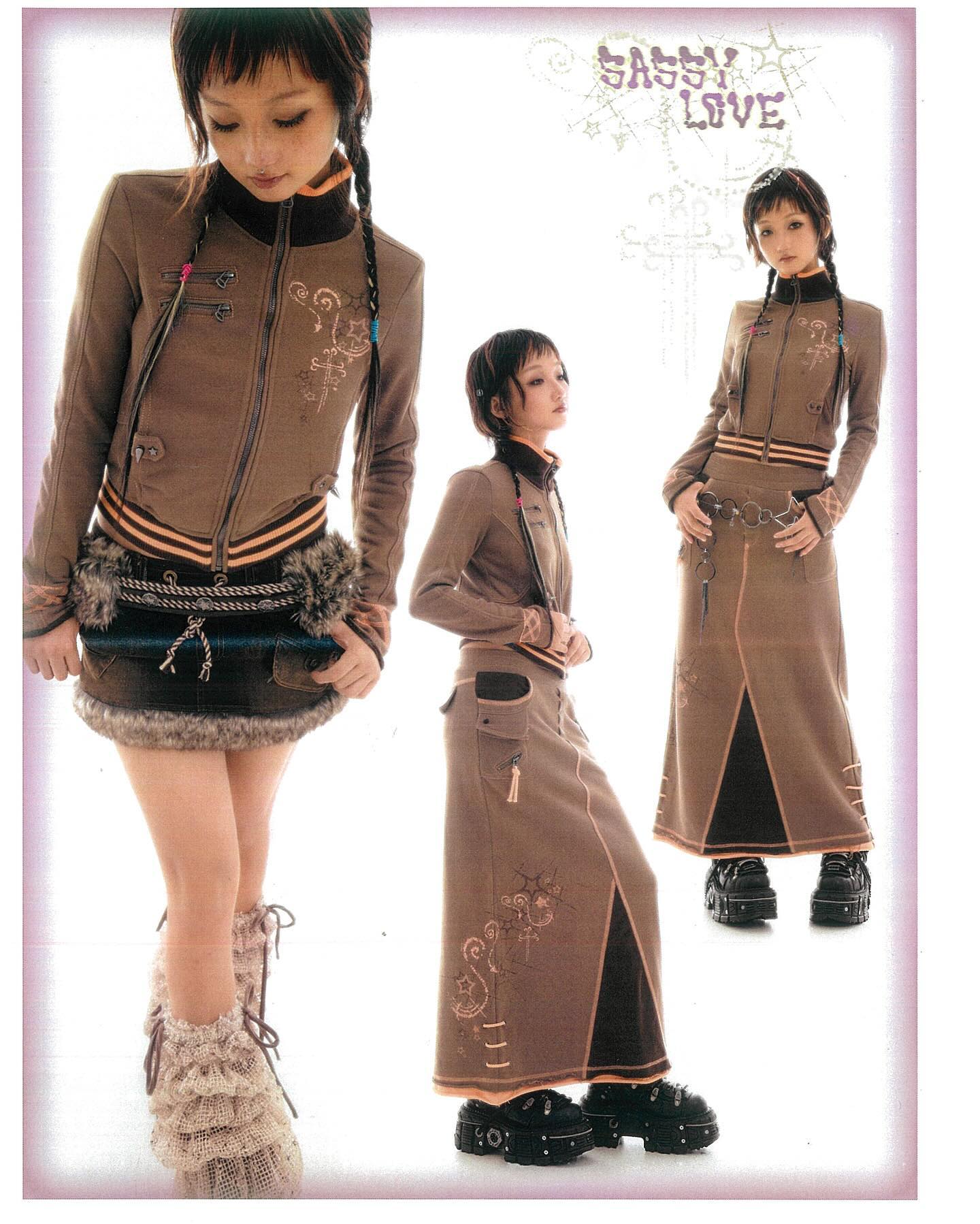a fashion photoshoot showcasing three young women modeling different outfits from the same collection. the central image features a woman wearing a brown jacket and a short, furrytrimmed skirt. the two side images showcase the same jacket styled with a matching long skirt. the outfits feature embroidery and distinctive design elements. the models are wearing boots and accessorizing their look. the background features a text logo that reads "sassy love". the overall aesthetic blends elements of japanese fashion, lolita fashion, and grunge fashion.