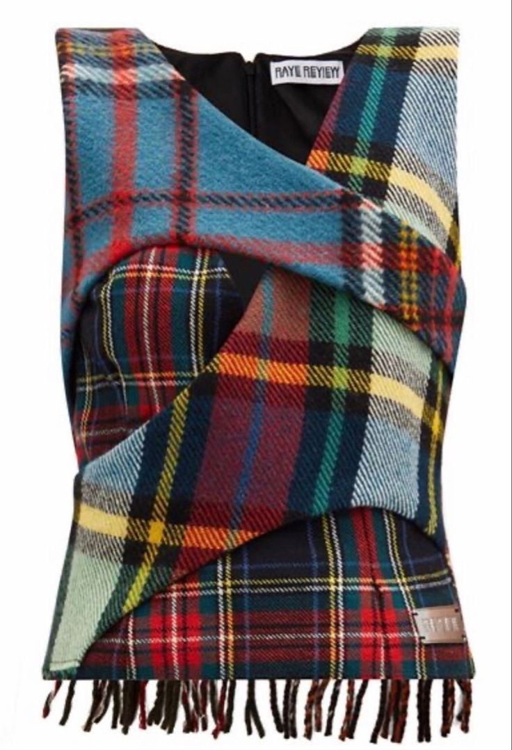 a women's plaid vest with fringe trim. the vest is made of a variety of plaid fabrics in red, blue, green, yellow, and black. the vest has a vneck and is sleeveless. the vest is made by raye review and has a tag on the front.