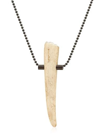 a closeup shot of a black chain necklace with a unique pendant made from an antler bone. the pendant is held in place by two black metal rings. the necklace has a simple and minimalist design, giving it a chic and modern look.