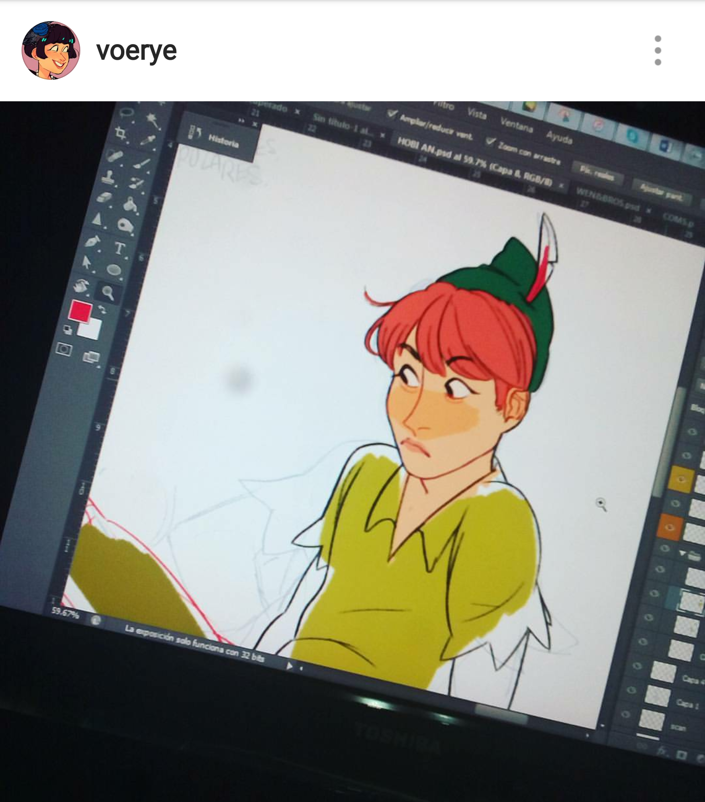 the image shows a screen displaying a digital drawing of peter pan. the artwork is in progress, with completed colors and outlines visible. the screen displays a digital painting interface, with various tools and palettes around the central image. the peter pan illustration has red hair and green outfit.