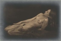 the image is a sepiatoned or monochrome photograph depicting a nude female figure reclining on a dark, indistinct surface. the woman's body is partially visible, with her head resting slightly elevated.  her long hair flows around her. the overall tone is dark and moody, with a focus on the form and texture of the body. the style suggests a vintage or possibly fine art photographic approach. the lack of sharp detail and the dark background contribute to the mysterious and sensual atmosphere.