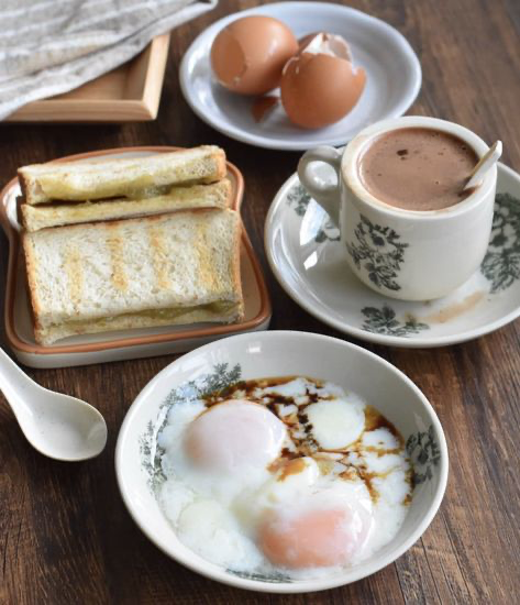 a delicious and classic asian breakfast of kaya toast, softboiled eggs, and kopi (coffee).