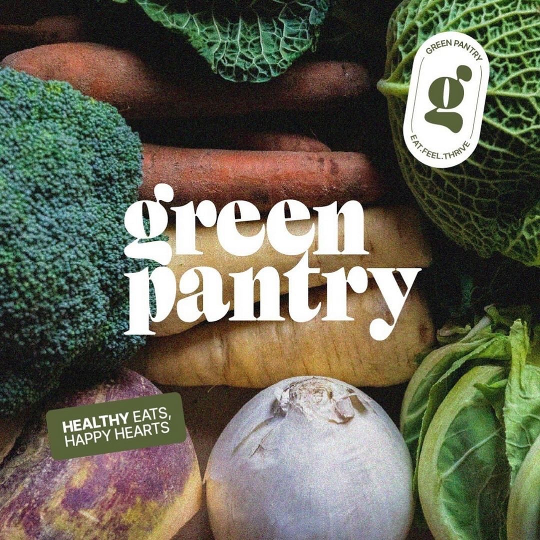 the image showcases a variety of fresh vegetables, including broccoli, cabbage, carrots, and parsnips. the vegetables are arranged in a visually appealing manner, filling the entire frame. a logo for "green pantry" is prominently displayed in the center, accompanied by their tagline "healthy eats, happy hearts". a smaller, circular logo reading "green pantry, eat.feel.thrive" is situated in the upper right corner. the overall aesthetic promotes healthy eating and fresh produce.
