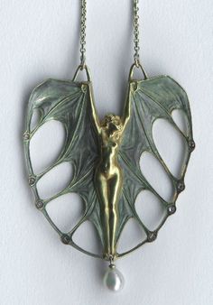 a closeup shot of an antique art nouveau pendant necklace featuring a female figure with wings, resembling a bat, all crafted in silver and bronze with a pearl hanging from the bottom.