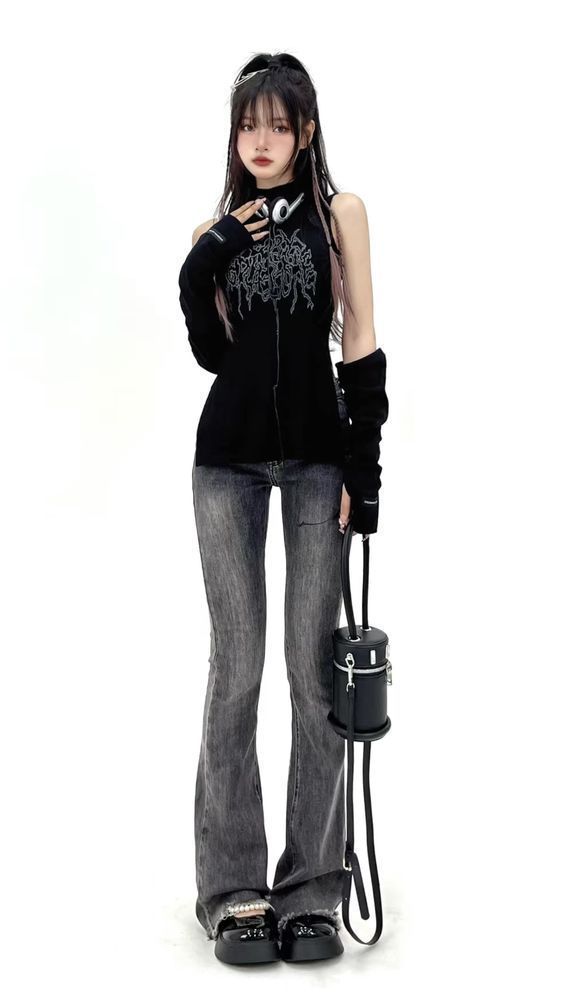 a fullbody studio shot of a young woman posing against a white background. she's wearing a black turtleneck sleeveless top with long black sleeves, grey flared jeans, black platform shoes and a small black cylindrical handbag. her hair is styled straight and she's wearing minimal jewelry.  the overall style is dark, edgy and fashionable.
