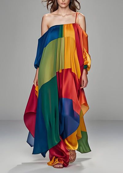 a woman in a vibrant, multicolored silk dress poses on a runway. the dress has a flowing, asymmetrical design and features a variety of bold hues, creating a stunning visual impact. the model's confident posture and stylish accessories enhance the overall elegance and glamour of the ensemble.