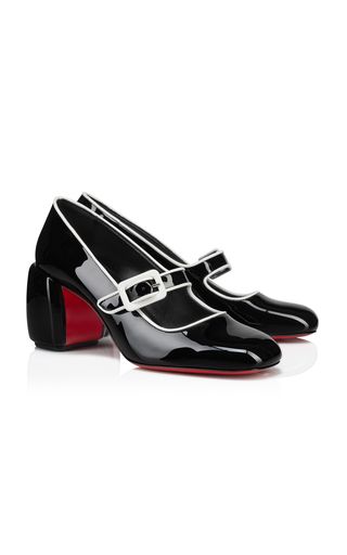a pair of black patent leather shoes with white trim and red soles. the shoes are mary jane style with chunky heels. they are women's shoes and are perfect for a dressy occasion.