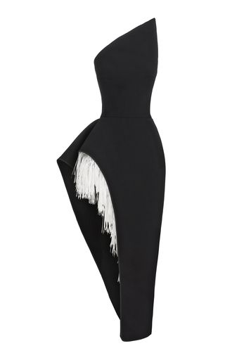 a black, oneshoulder cocktail dress with a fringe detail is shown on a white background.