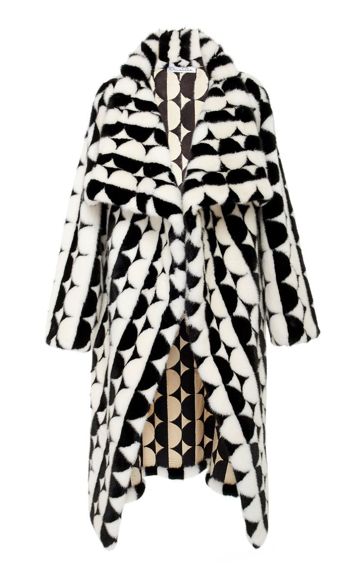 a black and white fur coat with a geometric pattern. the coat is longsleeved and has a wide collar. the pattern is made up of small circles and triangles. the coat is very stylish and chic. it would be a great statement piece for any winter wardrobe.