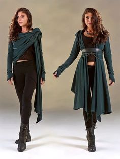 two women are modeling nearly identical outfits. the outfit consists of a dark green cardigan that can be worn open or belted, a black top, black leggings, and black boots. one woman has her cardigan open with the sleeves pushed up, while the other woman is wearing her cardigan closed and belted with a wide black belt. they are both posing with their legs apart and their arms slightly outstretched. the background is a plain white wall. the lighting is soft and artificial.