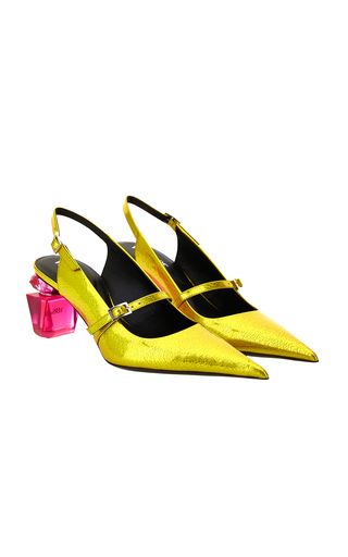 a pair of yellow, pointytoe slingback heels with a small heel. the shoes have a metallic finish and are set on a clear heel with a pink accent. they are elegant and stylish.
