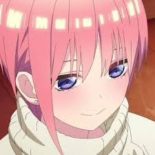 a closeup image of ichika nakano, an anime character, with pink hair and blue eyes. she is smiling and wearing a white sweater. her cheeks are slightly blushed.