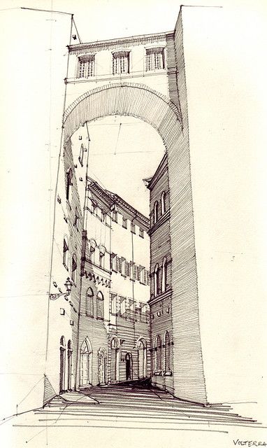 a black and white pen and ink architectural drawing depicts a cityscape with buildings and an archway spanning the street. the drawing utilizes perspective to create depth, and the artist's signature "volterra" is visible in the bottom right corner.